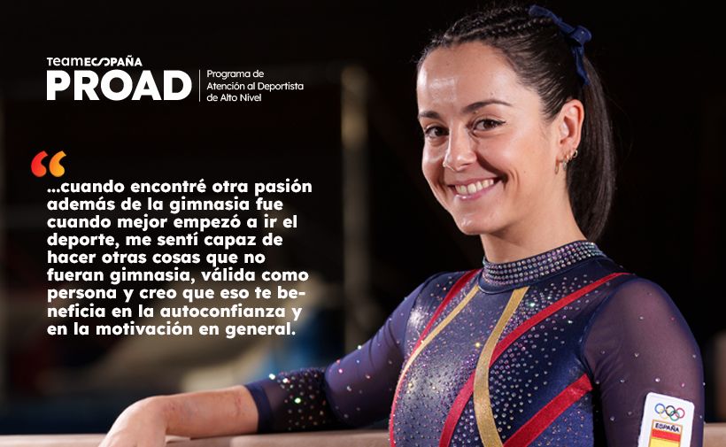 Cartel promocional del programa “Team España PROAD” con una foto de una gimnasta en primer plano y un texto de cita a la izquierda. El fondo es oscuro y la gimnasta aparece a la derecha, sonriendo, con el pelo recogido y un lazo azul oscuro. Lleva un maillot azul marino con pedrería y líneas diagonales rojas y amarillas; en la manga se ve un parche con los aros olímpicos y la palabra “España”. En la parte superior izquierda aparece el logotipo y el texto “teamespaña PROAD” y, a la derecha de eso, “Programa de Atención al Deportista de Alto Nivel”.  Texto visible (verbatim): teamespaña PROAD Programa de Atención al Deportista de Alto Nivel  “…cuando encontré otra pasión además de la gimnasia fue cuando mejor empezó a ir el deporte, me sentí capaz de hacer otras cosas que no fueran gimnasia, válida como persona y creo que eso te beneficia en la autoconfianza y en la motivación en general.”